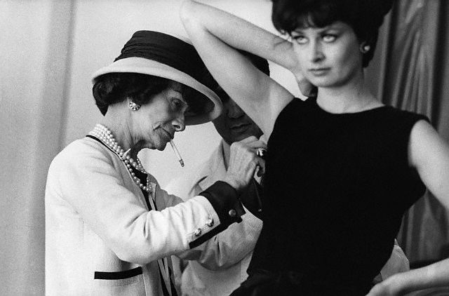 Coco Chanel Adjusting a Model's Dress